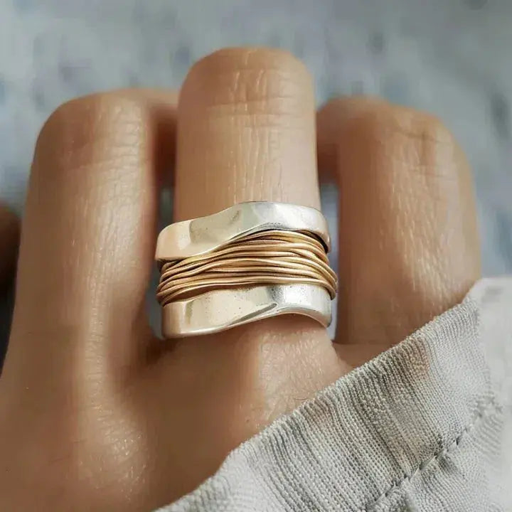 Anillo plateado con diseño de hilo dorado